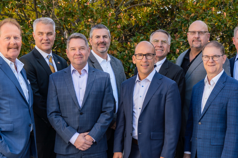 group of allworth partners in business suits, smiling