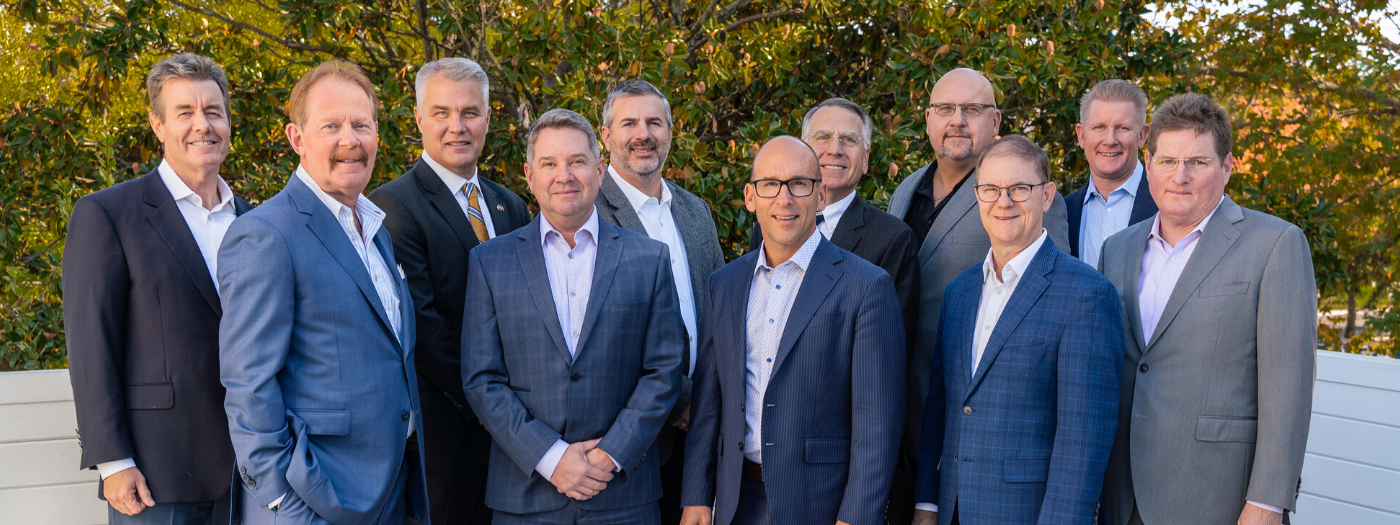 group of allworth partners in business suits, smiling