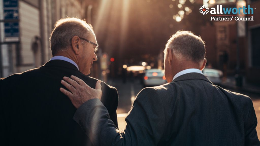 two professional business men walking down a sunny street and patting each other on the back