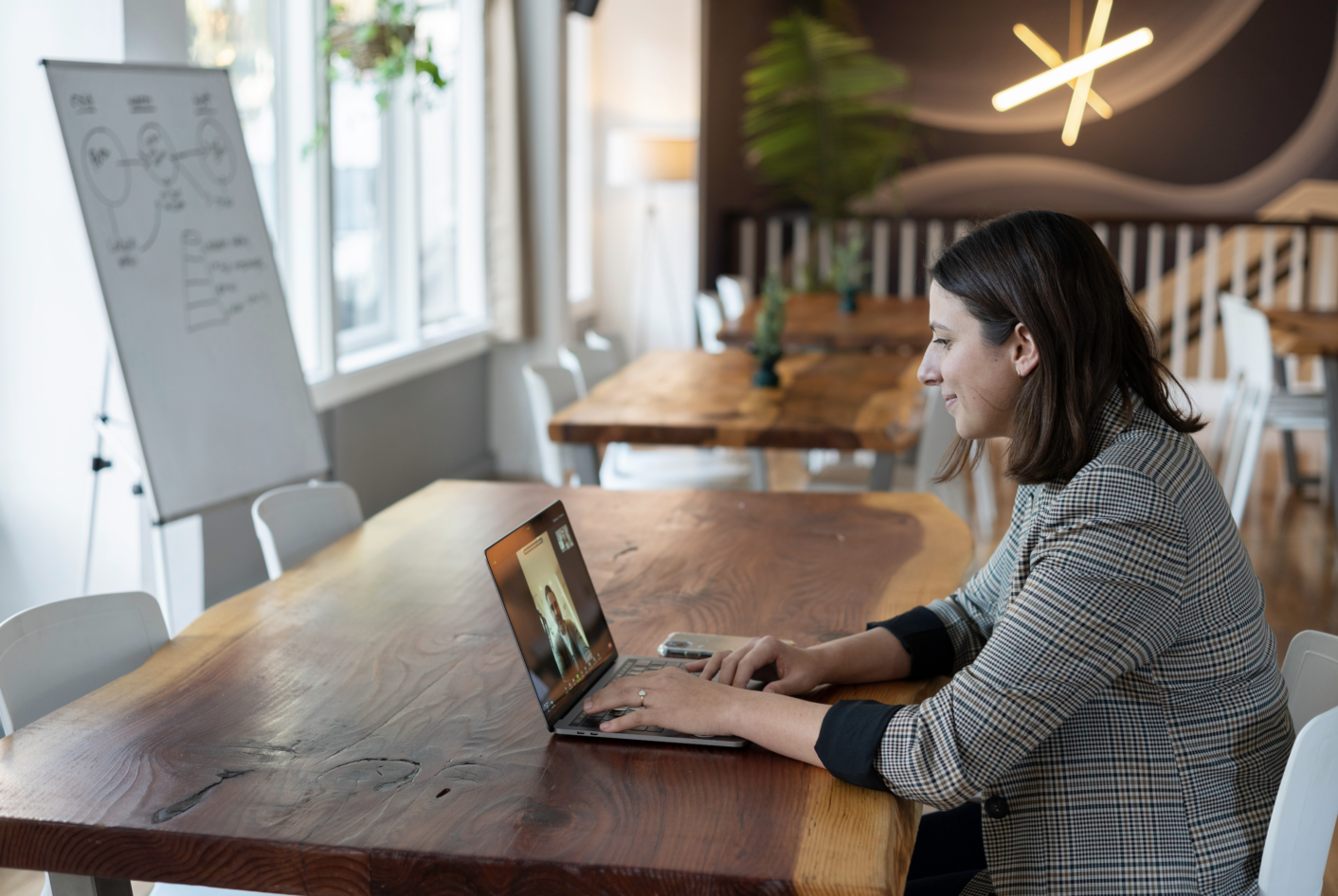 woman having a video meeting on her laptop in an open office space