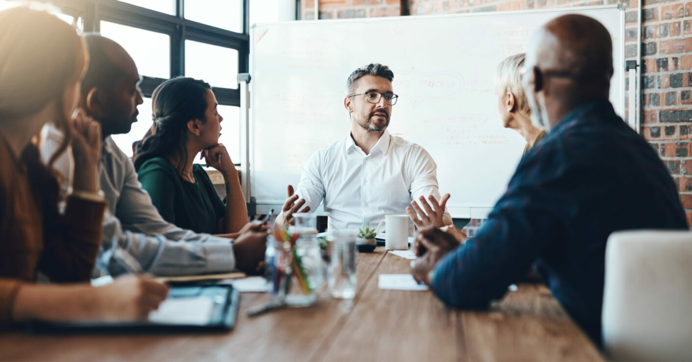 Team of people having a focused whiteboard meeting